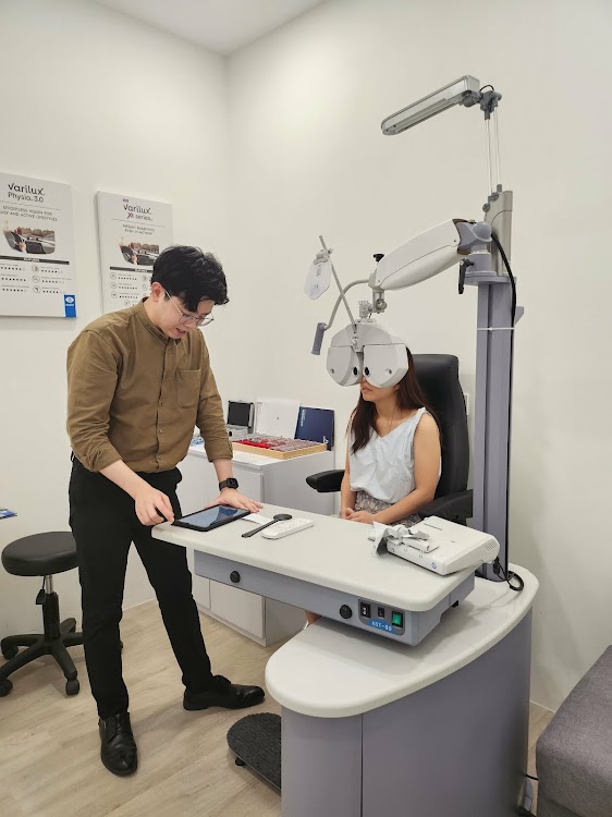 Optometrist performing an eye test at Moment Optical